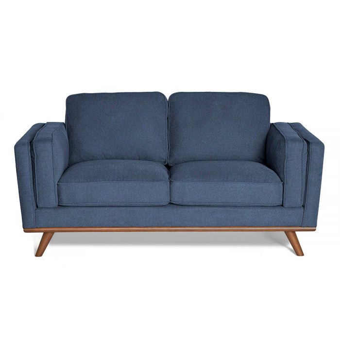 The Maddox Loveseat is a mid-century modern blue piece with wooden legs, square arms, and plush cushions. Its clean design is enhanced by a soft upholstered finish.