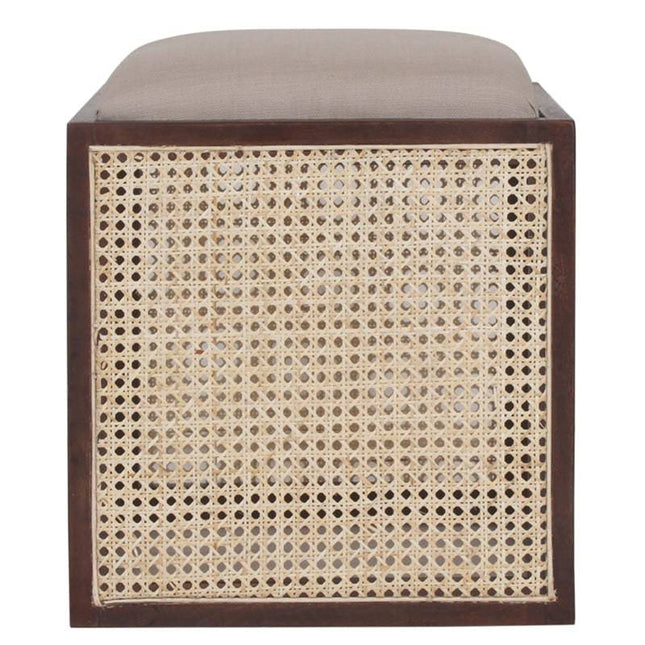 The Upholstered Stool With Cane features a square design with a brown wooden frame and beige cushioned top. Its sides boast a woven rattan pattern, similar to a Cane Cube Ottoman, adding texture and elegance to any space.