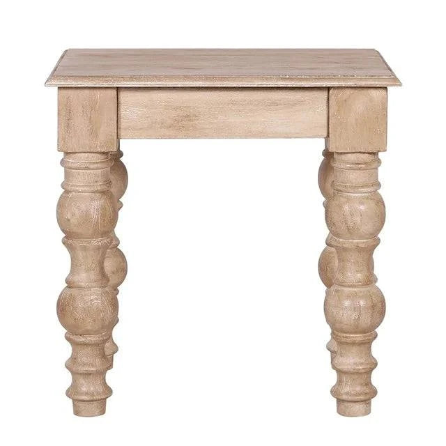The French Country Side Table is crafted from solid mango wood, featuring a square top and intricately carved thick round legs. Its distressed natural finish adds to its rustic, antique charm, exuding a classic French-country design.