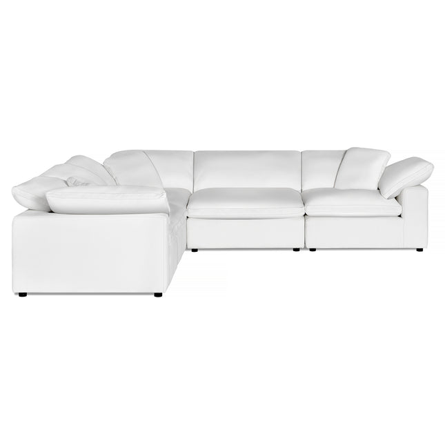 A modern L-shaped sectional sofa with plush cushions is upholstered in a smooth, elegant white fabric. It rests on small, discreet legs, offering a sleek and stylish appearance.