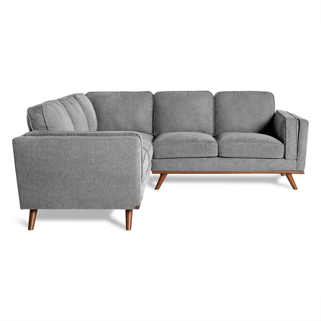 The Maddox is a modern gray sectional sofa with wooden legs in a mid-century design. Its three cushioned sections form an L-shape, with soft fabric adding comfort and elegance, perfectly complementing any living room décor against a crisp white background.