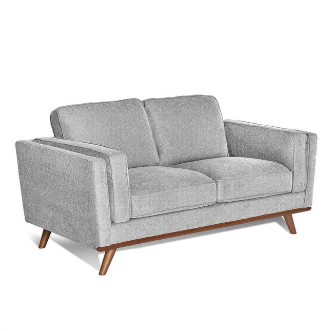 The Maddox Loveseat combines style and comfort with plush cushions, wide armrests, a slightly angled back, and mid-century modern flair. Its grey upholstery complements the brown wooden base and legs for a contemporary look.