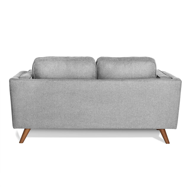 Back view of the Maddox Loveseat featuring plush back cushions, smooth upholstery, and outward-angled wooden legs. Its minimalist design with mid-century modern influences makes it perfect for contemporary living spaces.
