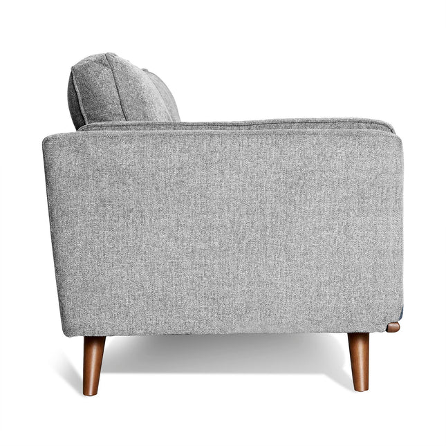The Maddox Loveseat is a grey upholstered piece with clean lines and tapered wooden legs, showcasing mid-century modern style. Its textured fabric and plush cushions offer a minimalist yet modern appeal against a crisp white background.