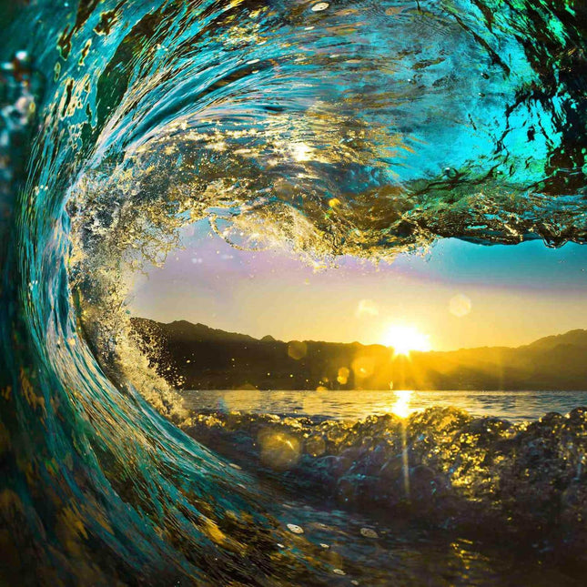 The Tidal Wave artwork depicts a large ocean wave with sunlight shimmering through its translucent blue and teal waters. Perfect for home or office, it captures the warm golden hues of a sunset over distant mountains and a reflective sea surface in museum-quality detail.