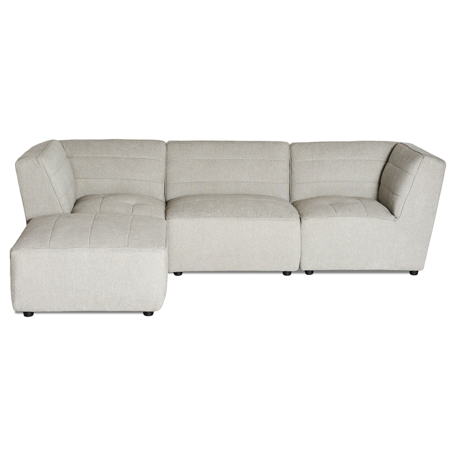 The Millenium 3 Piece + Ottoman is a light gray, L-shaped modular sectional sofa that features clean lines, tufted cushions for plush comfort, low black feet, and offers ample seating with a touch of modern luxury.