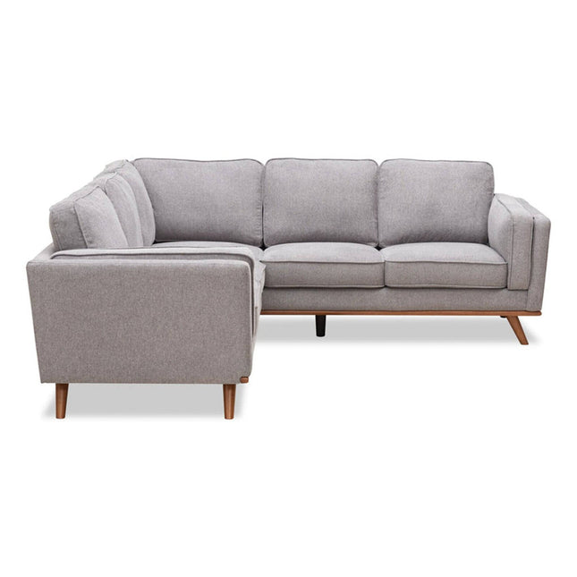 The Free Fabric Swatches sectional is a modern gray sofa with clean lines, wooden legs, a left-facing chaise, and plush cushions. Its smooth, neatly tailored fabric enhances any contemporary living space while offering a cozy seating arrangement.