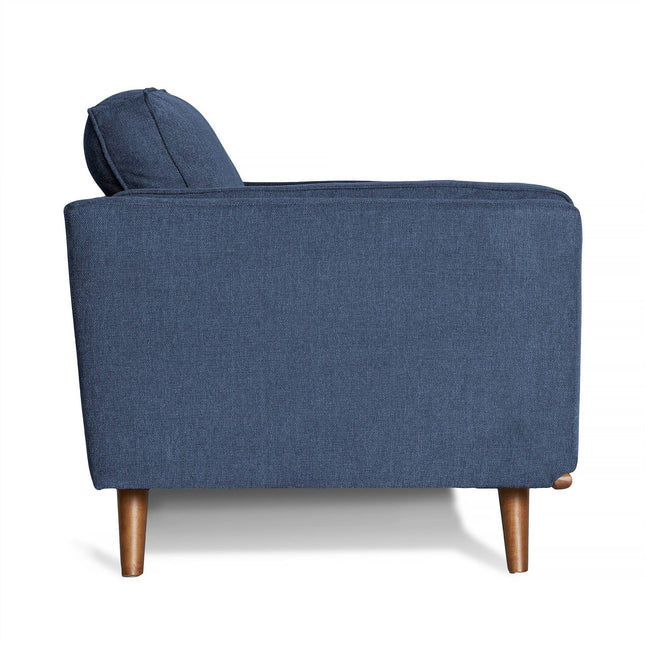 A side view of the Maddox Loveseat showcases its modern mid-century design with plush blue fabric, wooden legs, and an elegantly cushioned backrest against a white background.