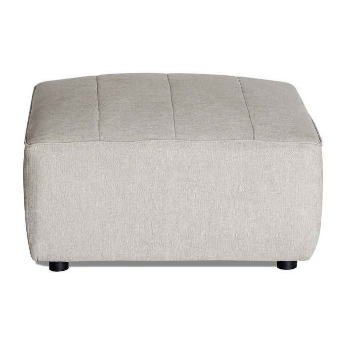 Introducing the Millenium Ottoman: a light gray, rectangular piece with modern luxury, subtle top stitching, and a smooth texture. It stands on four small black legs and perfectly complements any modular sofa.