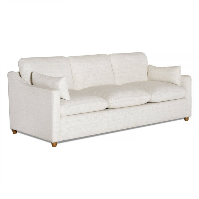 Meet the My Cloud Slope Sofa, a white three-seater embodying comfort with plush rectangular cushions and wooden legs. Its modern design includes slightly curved armrests and a textured fabric finish, merging style and tailored comfort seamlessly to enhance any space.