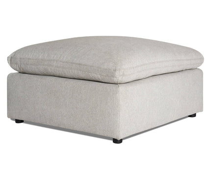 The My Cloud 40 Ottoman is a large, light gray piece with plush cushioning and small black feet, featuring a sleek, modern design. Its clean lines and soft upholstery make it an ideal addition to any living room or lounge area.