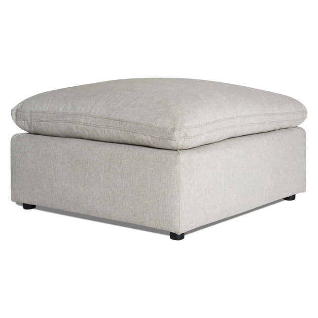 The My Cloud 40 Ottoman is a large, light gray piece with plush cushioning and small black feet, featuring a sleek, modern design. Its clean lines and soft upholstery make it an ideal addition to any living room or lounge area.