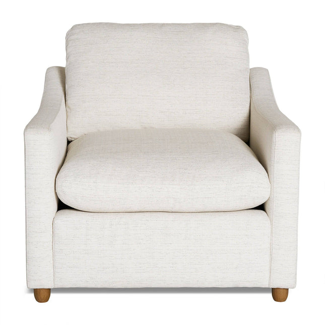 The My Cloud Slope Chair in beige features cushioned back and seat with wooden legs, offering comfort and style. Its simple, modern design includes slightly curved armrests. Set against a white backdrop, this chair highlights its stylish upholstery and structure.