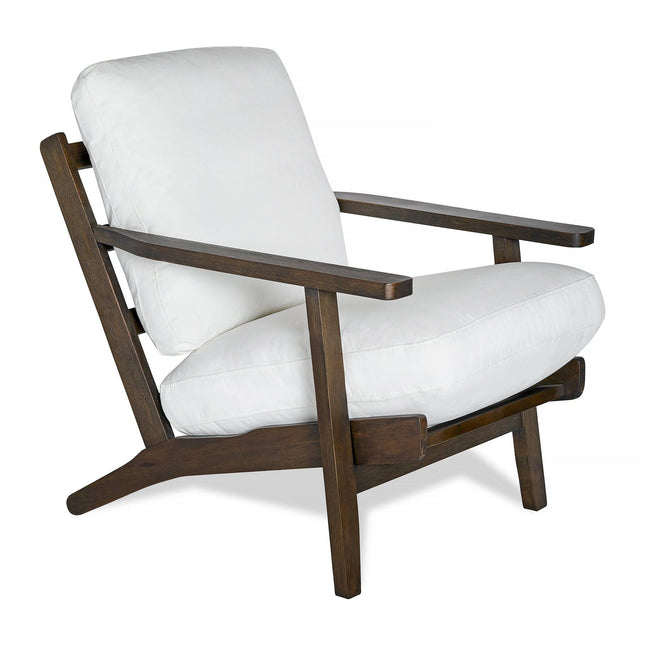 The Peyton Chair is a modern armchair with wide armrests, an angled back, and a dark wooden frame paired with white cushions. It seamlessly blends mid-century style with comfort, offering an ideal fusion of form and function.