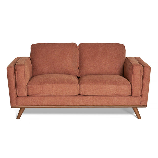 The Maddox Loveseat, featuring brown plush cushions and armrests, showcases a mid-century modern design with outward-angled wooden legs. Its soft fabric upholstery adds a cozy and inviting look.