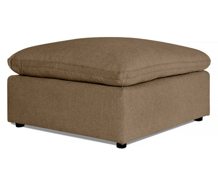 The My Cloud 40 Ottoman is a large square piece with beige textured fabric. Its plush, soft cushioned top offers comfort, while simple black feet at each corner enhance its understated elegance.