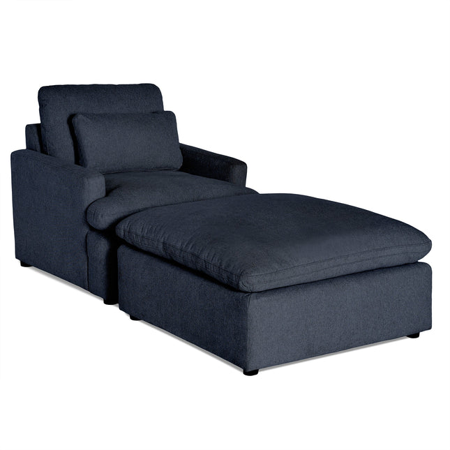 Introducing the My Cloud Chair, a dark gray fabric chaise lounge with thick cushions and a matching backrest pillow. It features a modern design with customizable options, offering a wide seat and low-profile build supported by sturdy black legs for exceptional comfort.